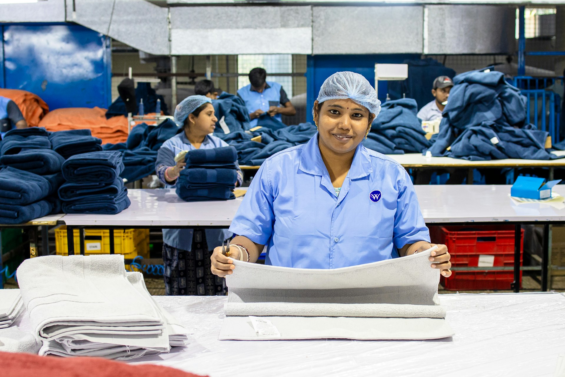 Factory workers folding clothes on a production line.